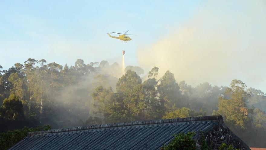 El helicóptero trabaja en la extinción de uno de los incendios registrados en Coiro. // Gonzalo Núñez