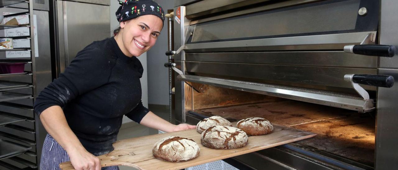 Carmen Gómez, sacando del horno alguna de las hogazas de pan elaboradas en su obrador.