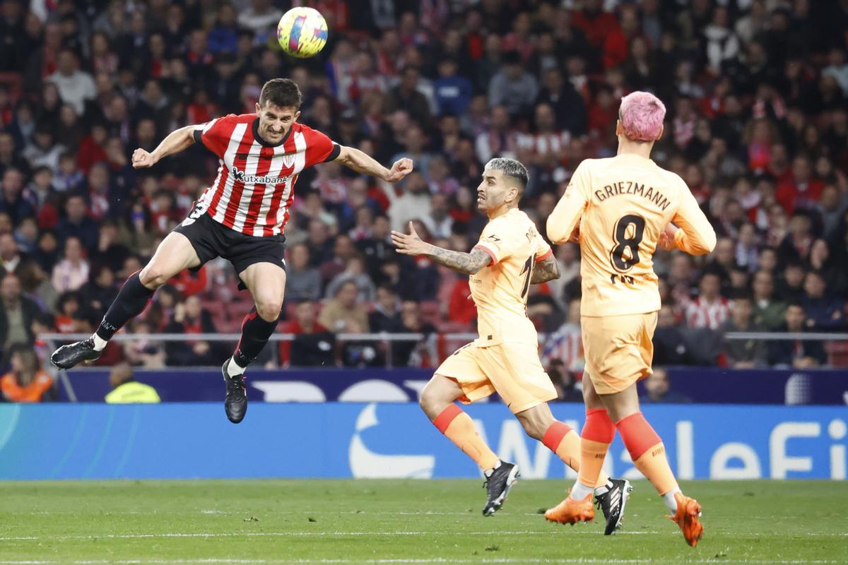 MADRID, 19/02/2023.- El defensa del Athletic Club, Dani Vivian (i), cabecea el balón ante los jugadores del Atlético de Madrid, el argentino Ángel Correa y el francés Antoine Griezmann, durante el encuentro correspondiente a la jornada 22 que disputan hoy domingo en el estadio Metropolitano, en Madrid. EFE / Juan Carlos Hidalgo.