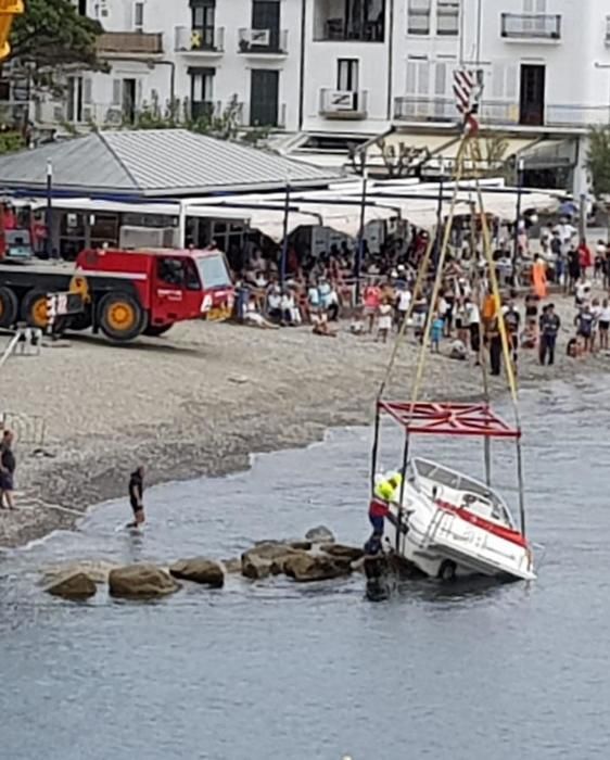 Una llanxa a la deriva s'enroca a tocar de la platja de Cadaqués