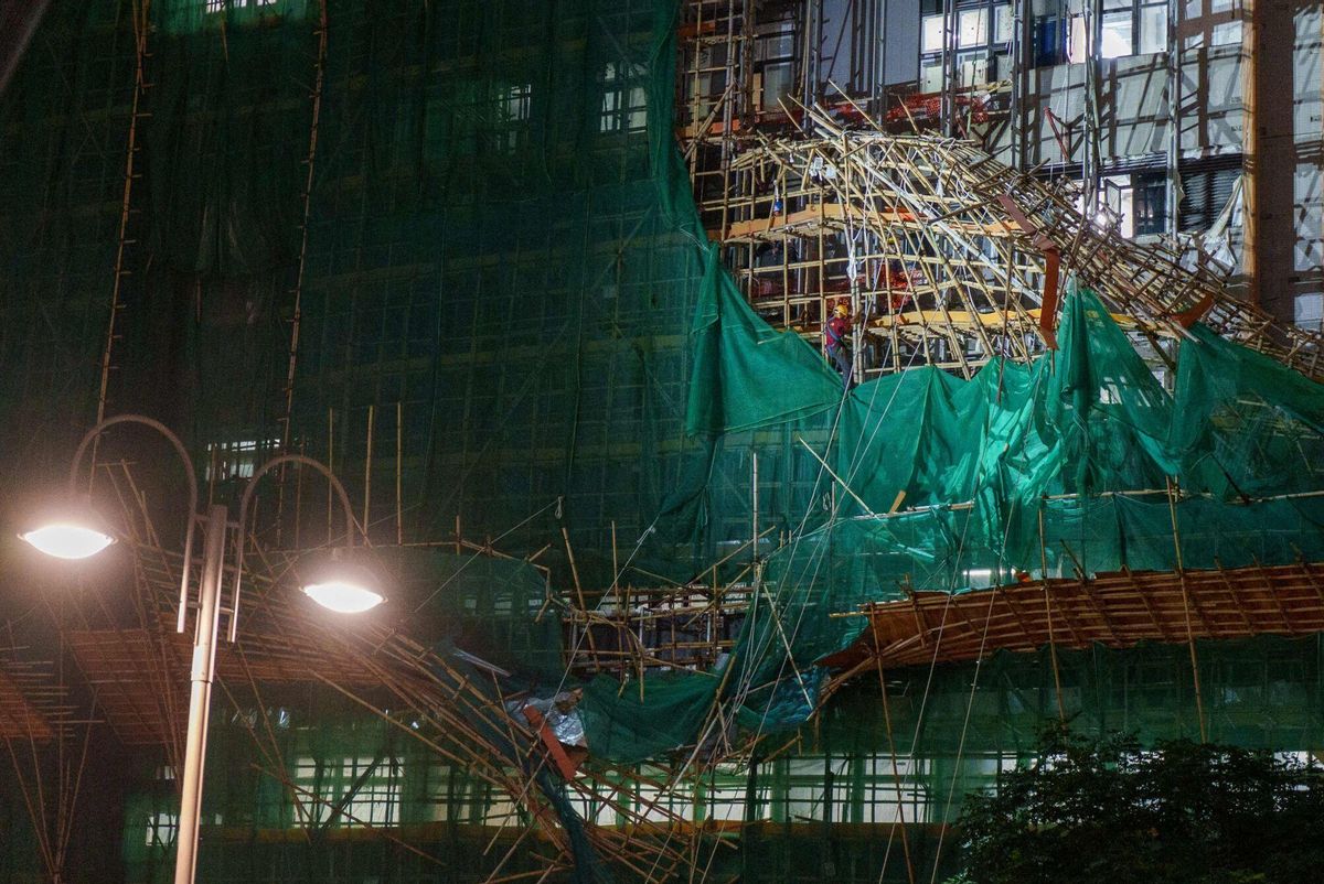 Workers work to remove collapsed scaffolding brought down by strong winds and heavy rain in Hong Kong on July 20, 2025, after Typhoon Wipha skirted along Chinas southern coast. Hong Kong issued its highest tropical cyclone warning July 20 as Typhoon Wipha battered the city, with authorities cancelling classes and grounding hundreds of flights. (Photo by YAN ZHAO / AFP)