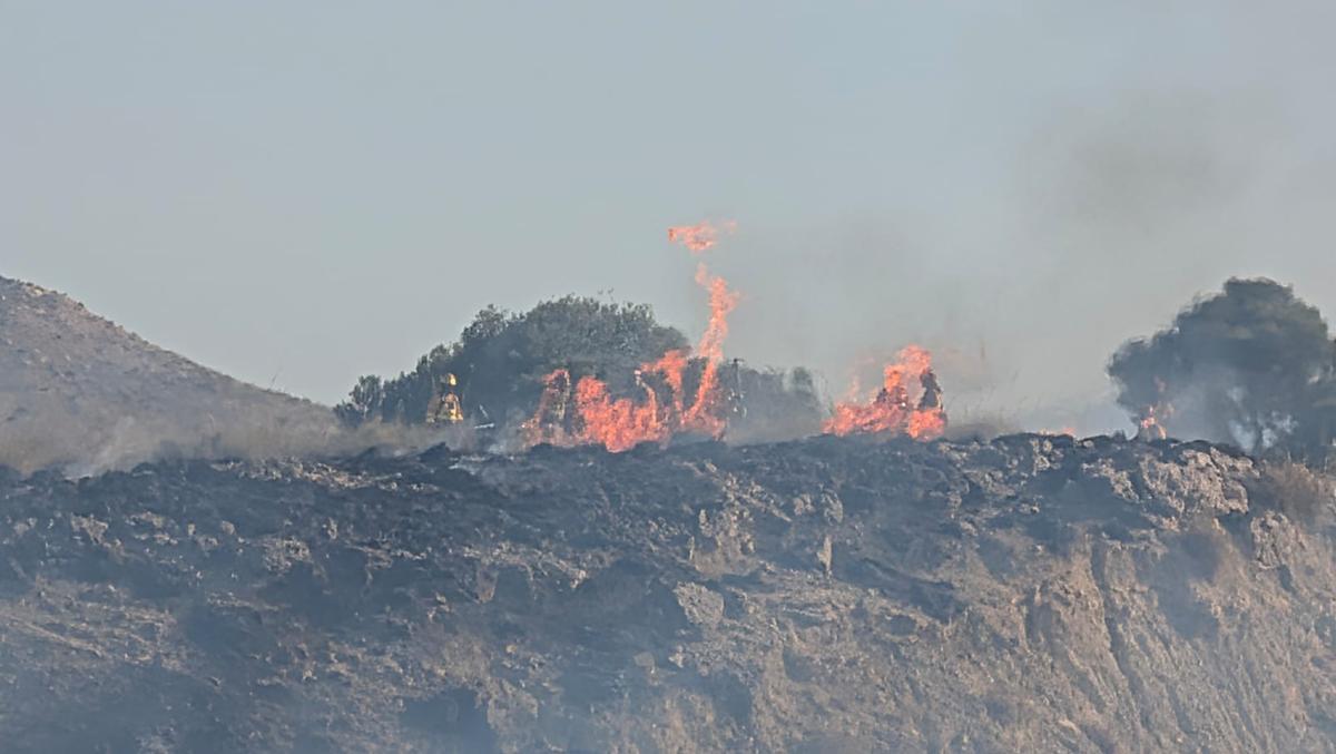 Bomberos y agentes medioambientales trabajan para apagar el incendio en La Paira.