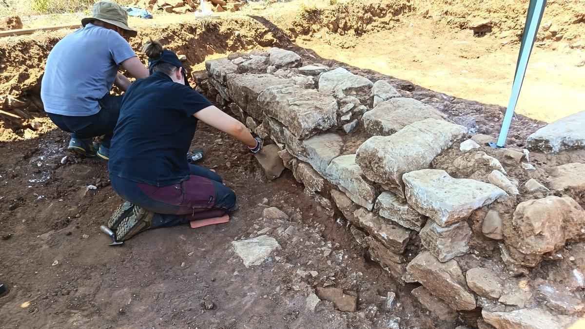 Gerardo Sierra y Celia Moya trabajando este lunes en la cara exterior del muro meridional de la nueva construcción descubierta en la excavación de La Estaca.