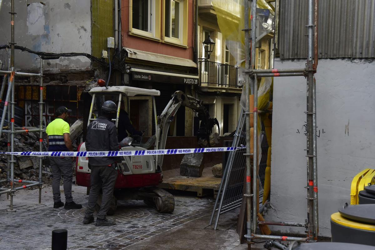 Precinto policial en la zona donde los operarios de la empresa de demolición retiran los restos y escombros.