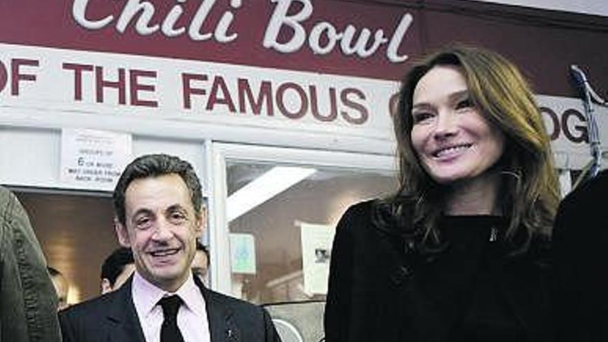 Nicolas Sarkozy y Carla Bruni, a la salida del local de perritos calientes. / efe