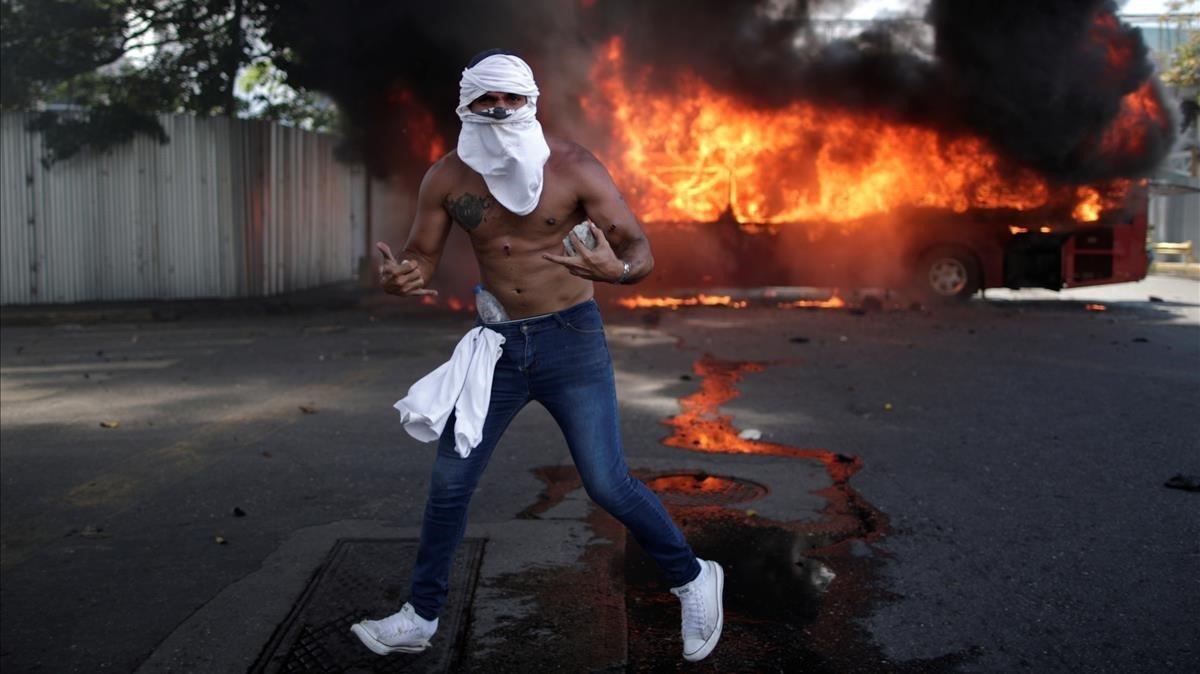 zentauroepp47960554 an opposition demonstrator gestures in front of a burning bu190430193348