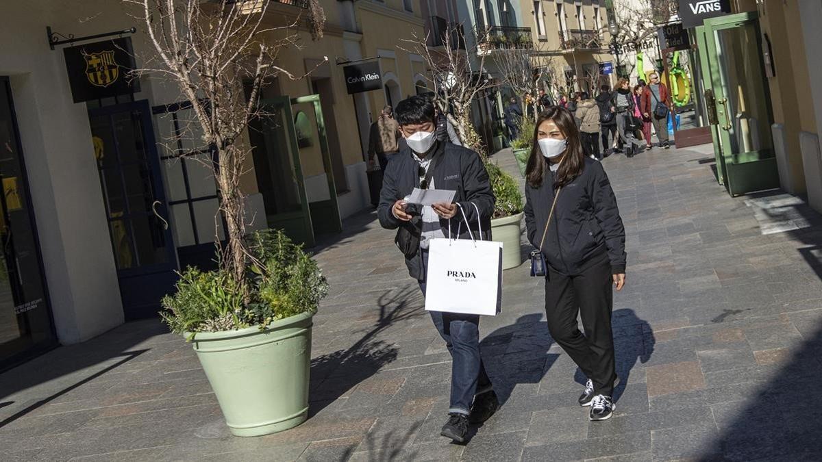 Dos clientes pasean por las tiendas de La Roca Village con mascarillas protectoras por miedo a contraer el coronavirus, el 5 de febrero del 2020