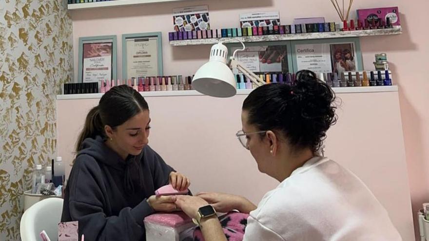 Alexia Vergel haciendo la manicura a una clienta.