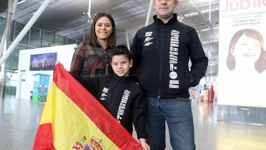 Christian Costoya sostiene una enseña nacional, ayer en Lavacolla, junto a sus padres. // Xoán Álvarez