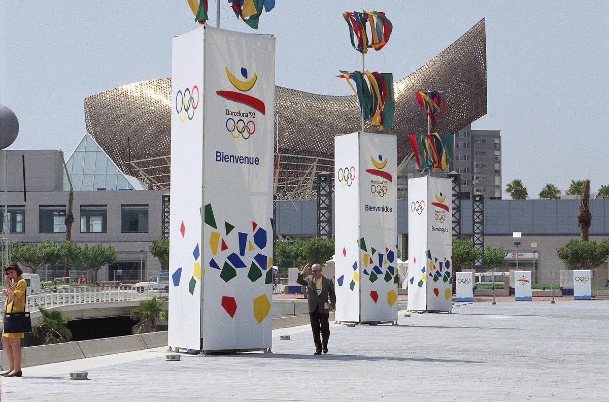 Un hombre pasea frente a unos carteles gigantes de los Juegos Olímpicos de Barcelona, en la Villa Olímpica, el 18 de julio de 1992.
