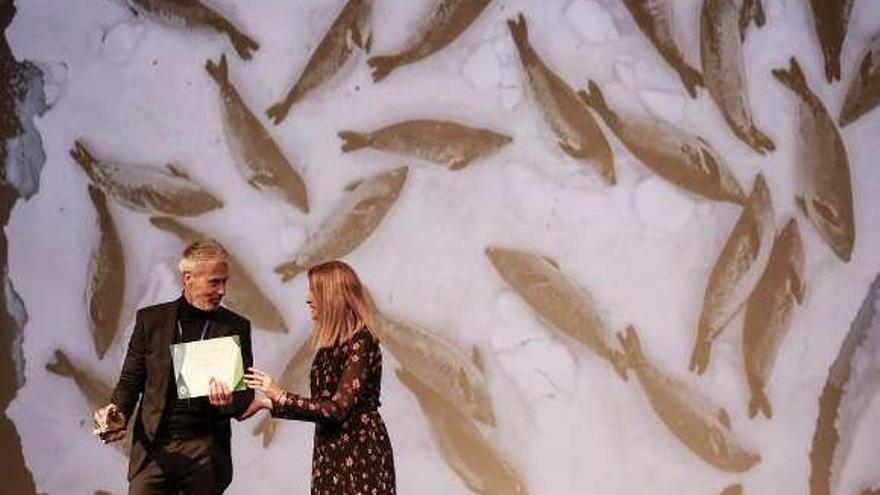 El ganador absoluto, Cristóbal Serrano, y la presentadora, con la foto premiada detrás.