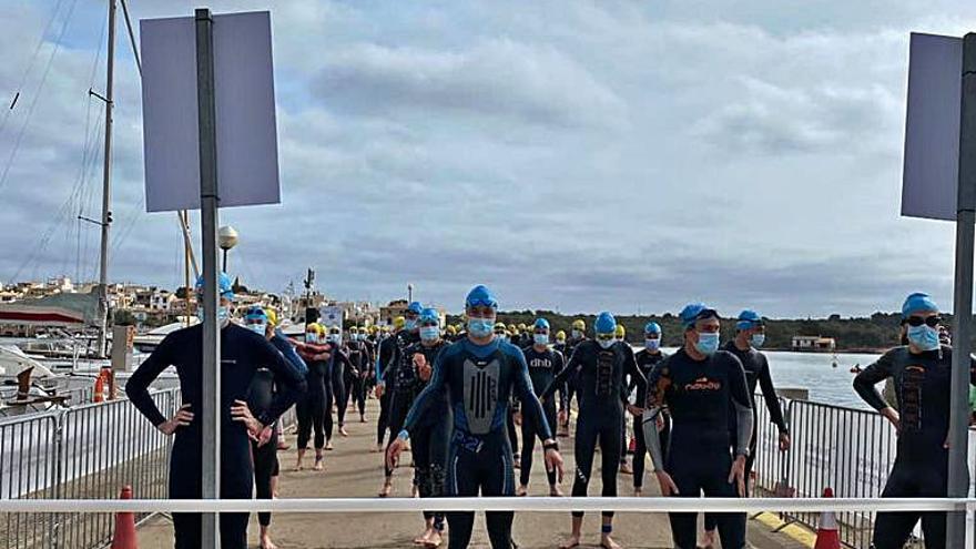 Los triatletas esperan la salida de la natación. 