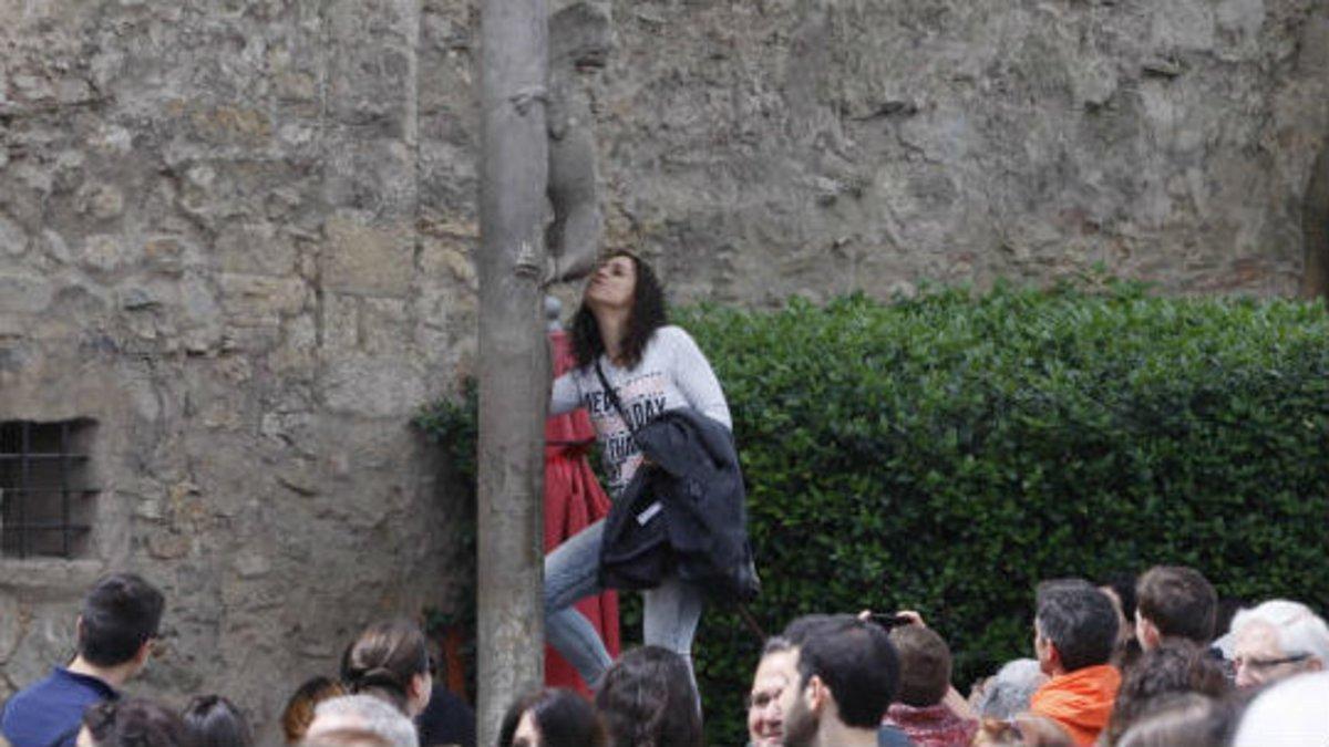 Una visitante da un beso a la estátua de la leona de Girona
