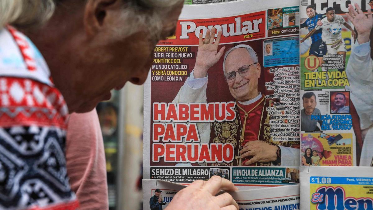 Una mujer mira las portadas de los periódicos peruanos que celebran el nombramiento del cardenal estadounidense Robert Prevost como nuevo Papa León XIV en un quiosco del centro de Lima el 9 de mayo de 2025.