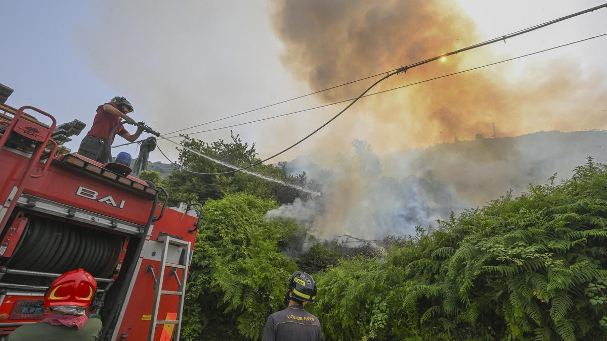 Imagen de archivo de un grupo de bomberos comabtiendo un incendio.