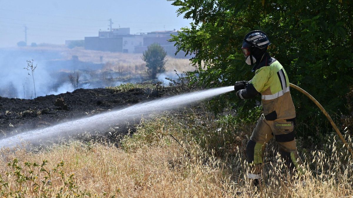 Un bombero de Badajoz trabaja para sofocar las llamas en la barriada de San Miguel este martes.