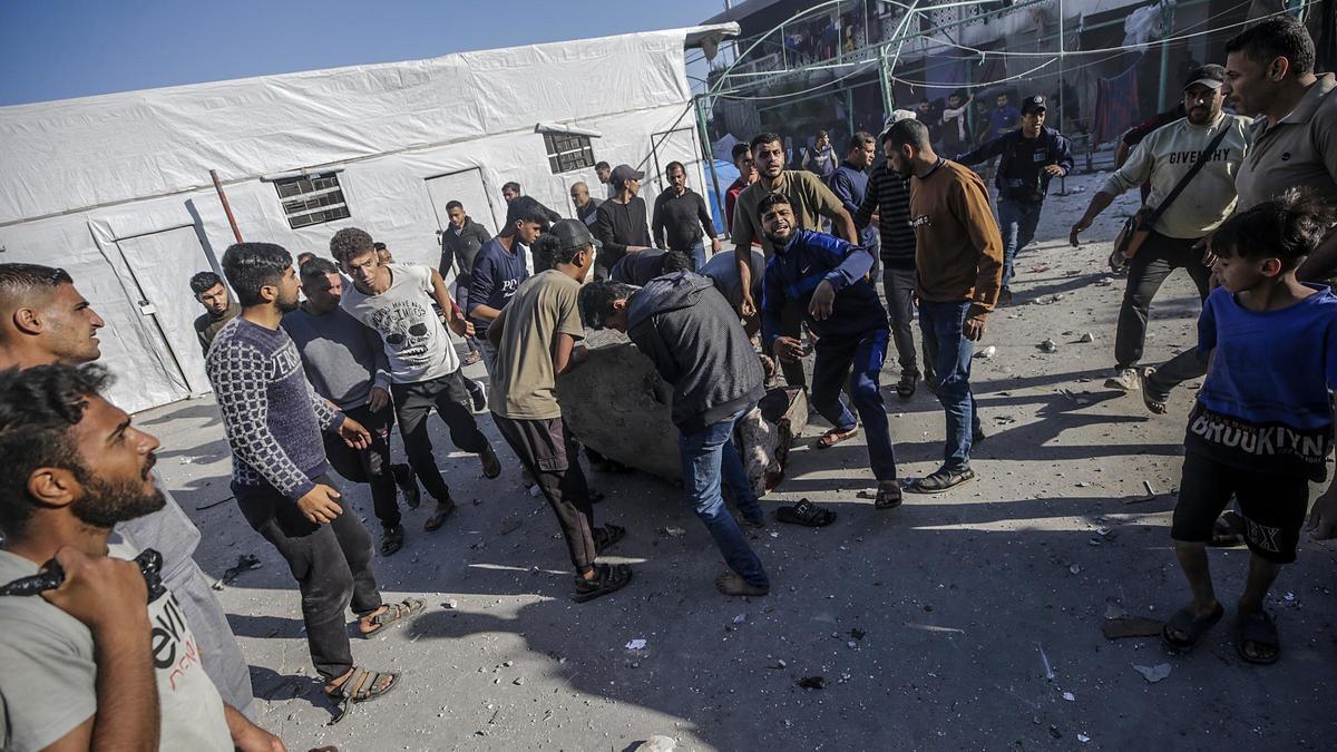 Palestinos portan un cuerpo tras un ataque de Israel sobre una escuela de Gaza, este viernes.