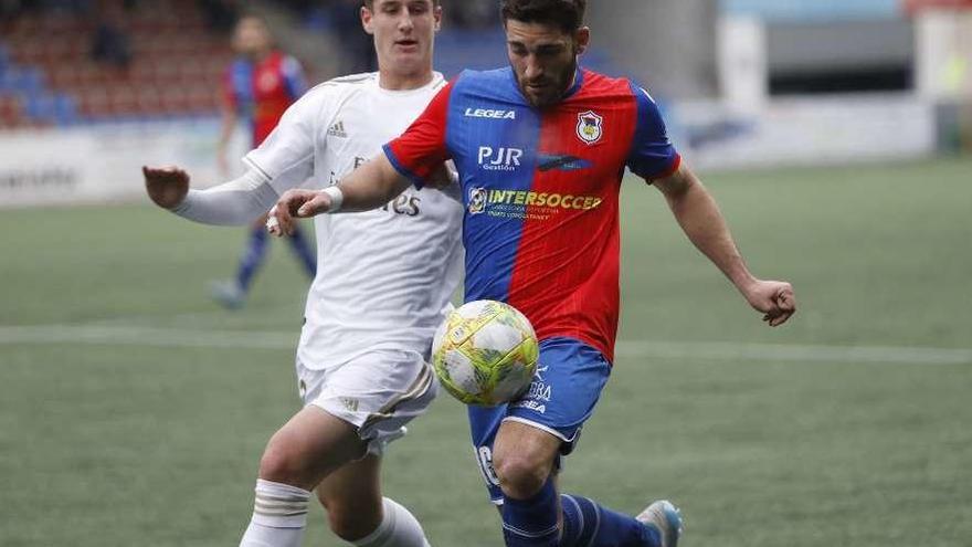 Ramón Riego se lleva el balón ante Baeza.