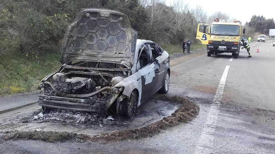 El coche calcinado, ayer, en plena Autovía del Cantábrico.