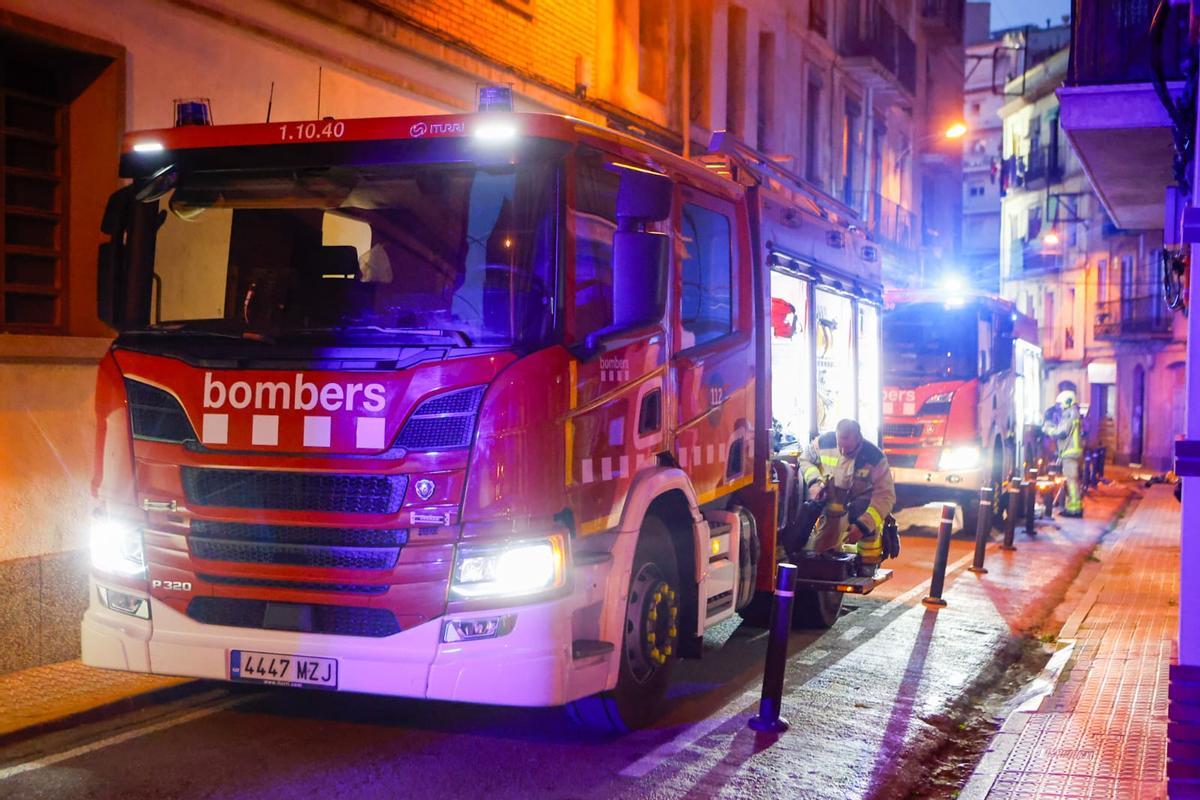 Un camió de bombers treballant en l'edifici afectat per el foc