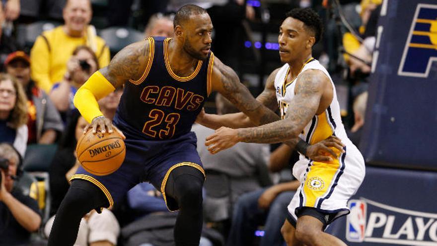 LeBron James bota la pelota ante la defensa de Jeff Teague.