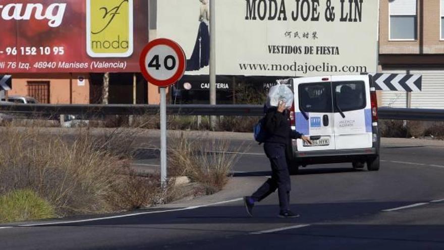 Una persona cruza la carretera para desplazarse desde el aeropuerto al polígono de Manises a pie.