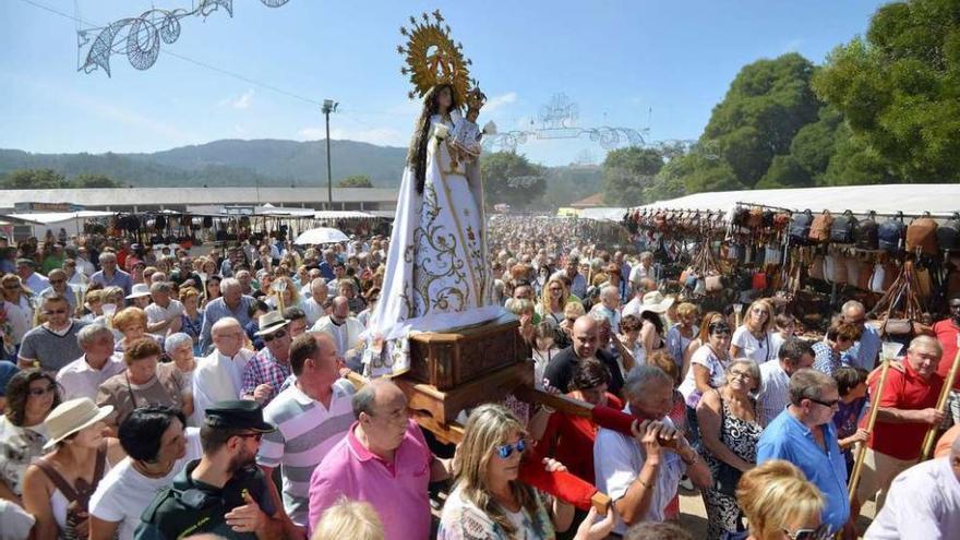 La Virgen de los Milagros durante la procesión de ayer, rodeada por miles de fieles en el exterior de la capilla. // Gustavo Santos