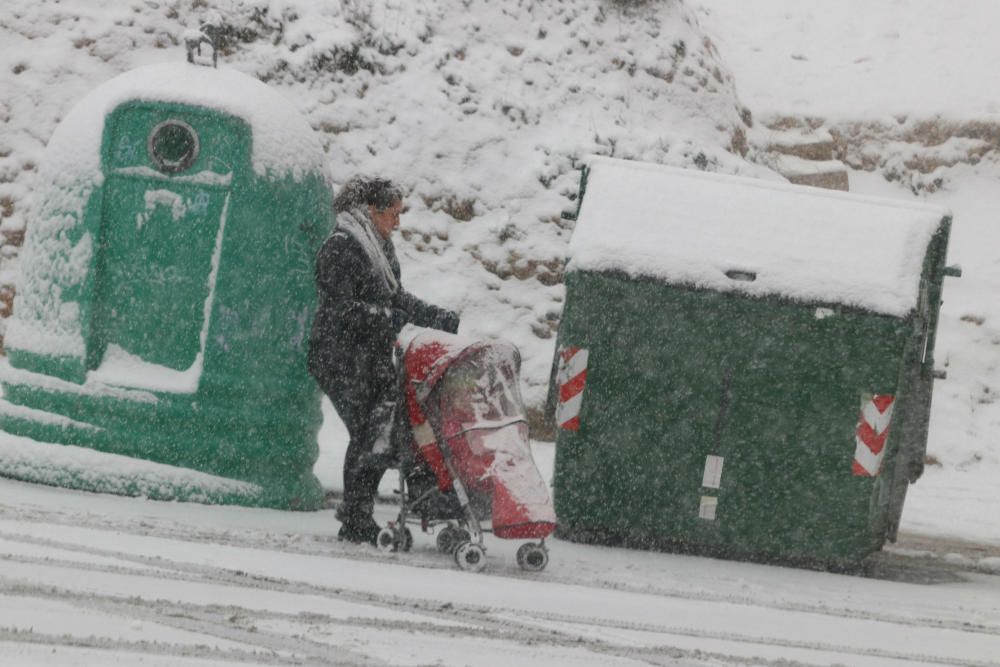 Una mujer con con carro tiene dificultades para caminar por la nevada