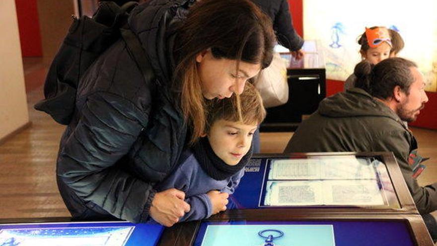 Una mare i el seu fill observen un mapa del museu