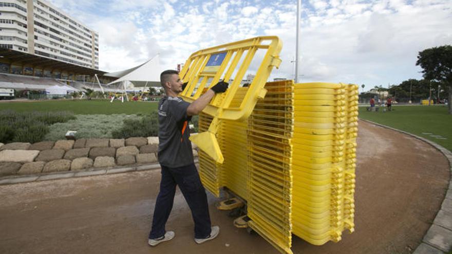 Un miembro de la organización retira las vallas de seguridad de la prueba en el parque del Estadio Insular.