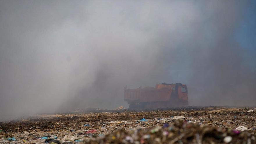 Un camión se dispone a descargar tierra sobre la zona donde se localizaba el incendio.