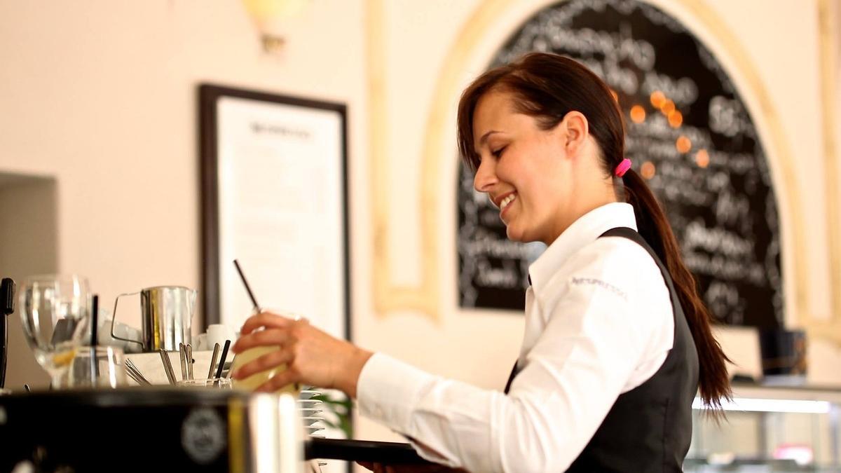 Una camarera mientras trabaja en un establecimiento de hostelería