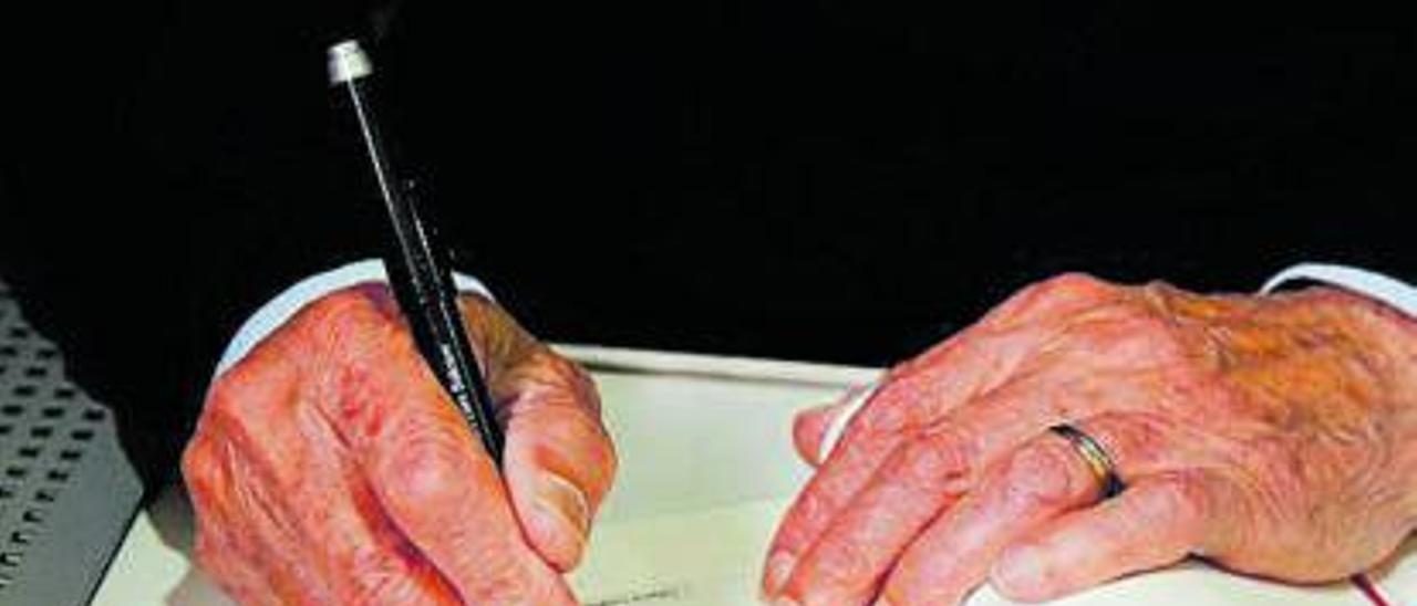 Un escritor firma un ejemplar en una feria del libro. . | | LA PROVINCIA/DLP