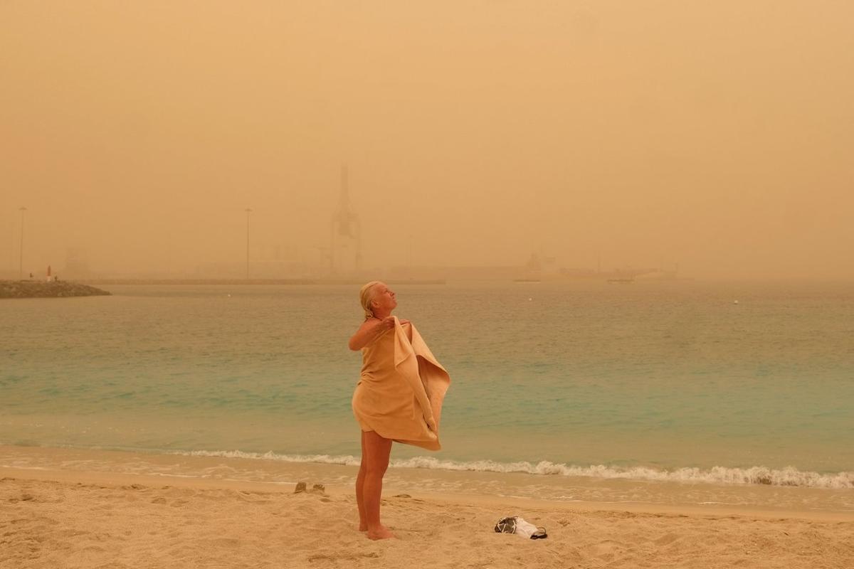 GRAFCAN1436. PUERTO DEL ROSARIO (FUERTEVENTURA), 22/02/2020.- Una turista toma un baño en Playa Chica en Puerto del Rosario. Canarias está afectada desde este sábado por una intensa calima (arena y polvo del desierto del Sáhara en suspensión) provocada por viento fuerte con rachas muy fuertes de componente este, que se intensificará el domingo, y puede superar los 80-100 km por hora, sobre todo en zonas altas y de medianías donde no se descarta que superen los 120 km/h. EFE/ Carlos De Saa