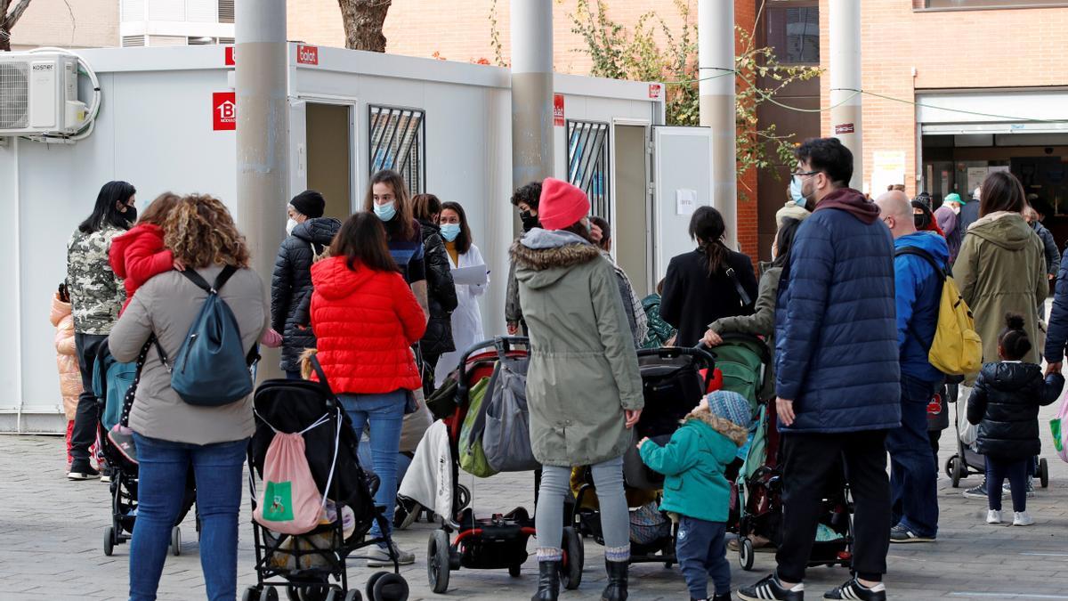 Padres hacen cola en Barcelona para realizar una PCR a sus hijos.