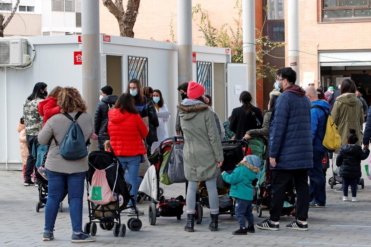 Padres hacen cola en Barcelona para realizar una PCR a sus hijos.