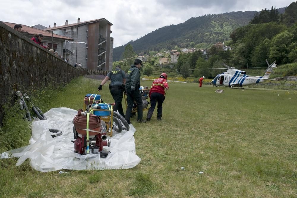 La Guardia Civil y el GES de Lobios cargan en el helicóptero las bombas de achique para reducir el caudal de la catarata.