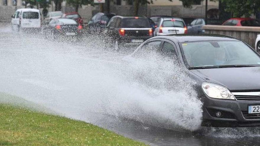 Un coche salpica agua de la lluvia, ayer, en A Coruña.