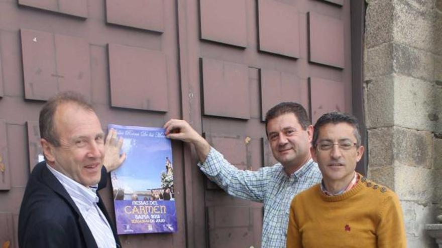 Por la izquierda, Cesáreo Fernández, Santiago Jarén y Ramón Pérez, en la puerta de la iglesia de Tapia, con un cartel de las fiestas del Carmen.