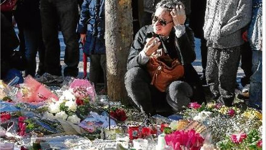 Una dona plora després de deixar una ofrena floral a prop de la sala de concerts Bataclan.