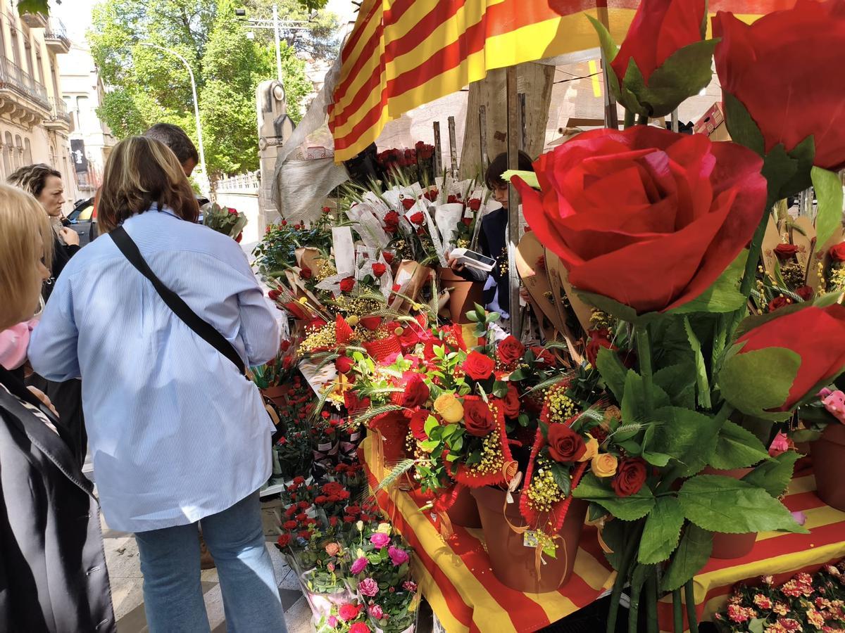 Imatge de gent comprant roses a la parada de Viver Serra
