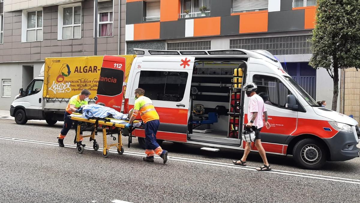 Sanitarios subiendo a la herida a la ambulancia en camilla.