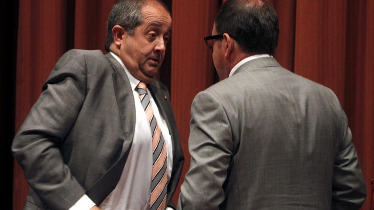 El 'conseller' Puig (izquierda) conversa con el diputado de CiU Xavier Crespo en el Parlament.