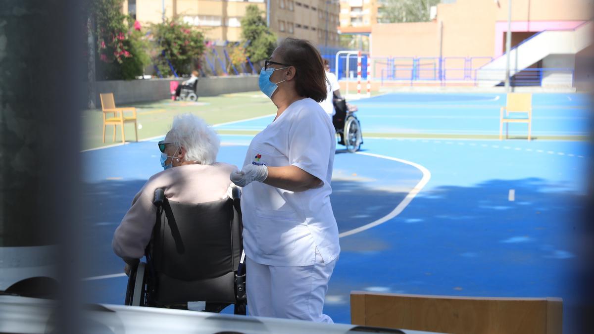 Una trabjadora realiza gimnasia con una usuaria en una residencia de Cartagena.