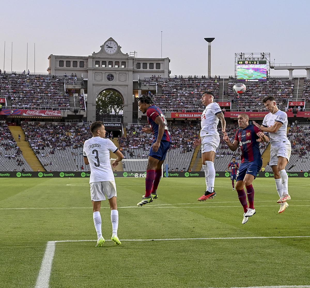 Estreno feliz en Montjuïc. Kounde y Oriol Romeu tratan de cabecear un centro durante el trofeo Joan Gamper que les enfrenta al Tottenham Hotspur en el estadi Olimpic Lluis Companys en Montjuïc.