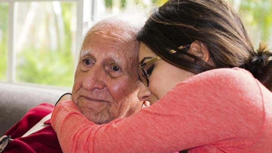 Una joven abraza a un enfermo de alzheimer