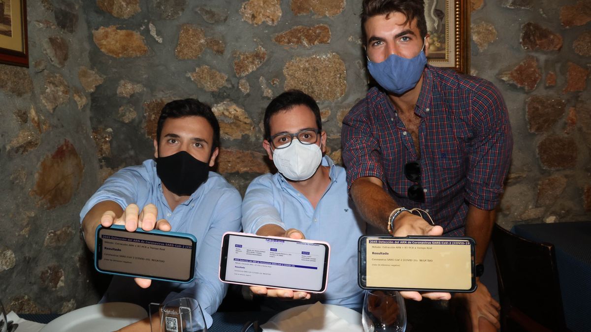 Tres clientes muestran sus certificados en un bar.