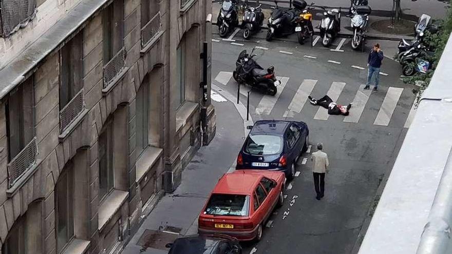 Una de las personas heridas por el agresor, ayer, tendida en medio de la calle. // Reuters