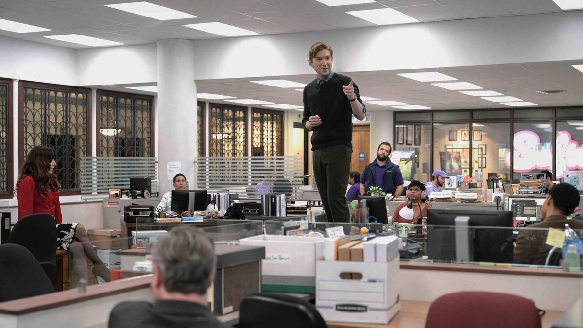 Domhnall Gleeson (Ned Sampson), de pie sobre un escritorio, en una imagen del piloto de 'The paper'