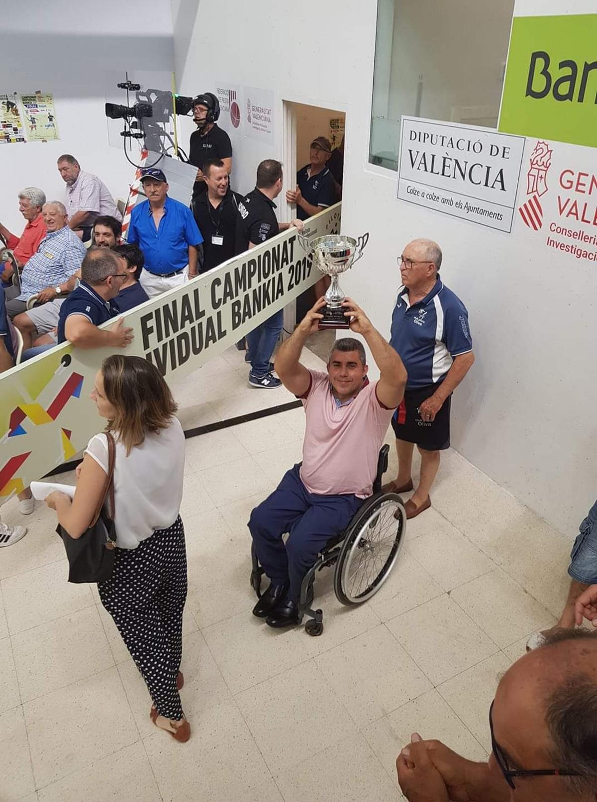 El deportista olivense exhibe uno de los numerosos trofeos que ha ganado